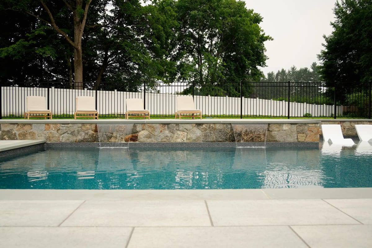 Exterior Services LLC — a stone veneer wall with four scuppers spilling into a finished pool in Brookfield, CT